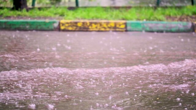drops of summer or autumn rain of water fall on asphalt in the city turning into a large puddle, flooding the street. Drops of rain fall. slow motion, general paln