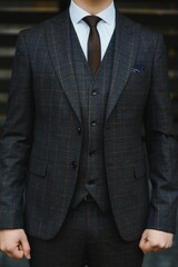 Portrait of handsome fashion businessman model dressed in elegant suit. Man posing on street background. Metrosexual