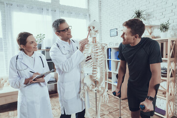 Obraz premium The doctor explains how an athlete's injury.