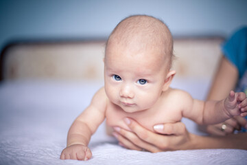 Baby with blue eyes portrait lying on bed