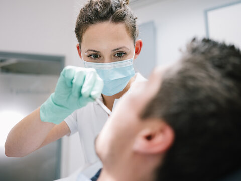 Junge Zahn&auml;rztin bei der Zahnprophylaxe