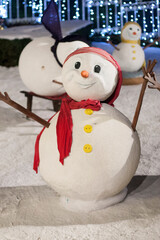 Snowman - Christmas street decoration, lights on background. Night time.