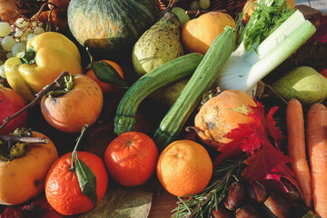 typical autumn fruits and vegetables in a colorful composition on wooden table