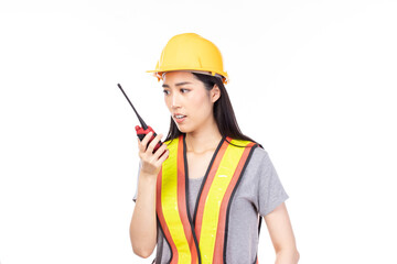 Beautiful young asian construction female worker in yellow helmet and reflective vest and using walkie talkie for talking with team staff isolated on white background.