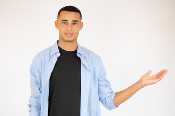 friendly young man pointing to his side and looking into the camera. isolated on white background