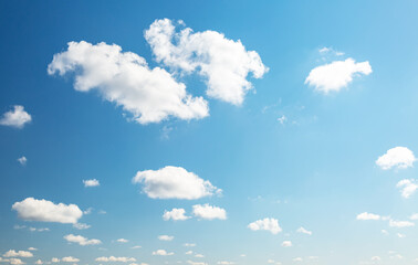 Blue sky background with white fluffy clouds in the fresh sunny day.