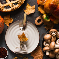 Fall thanksgiving table with roasting chicken or turkey, nuts, pie, pumkins and other food on black