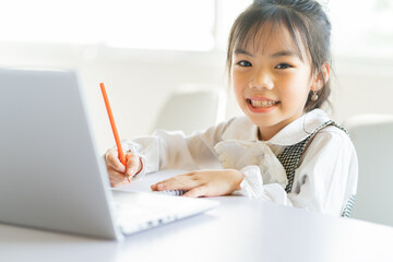 Asian girls studying online at home

