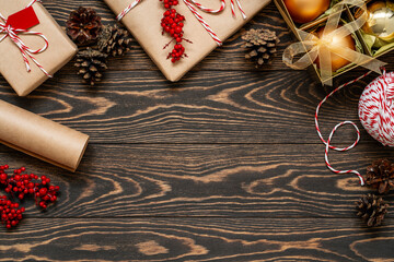 Christmas flat lay with decorated presents and ornaments on the brown wooden background. Top view...