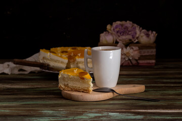 Apricot pie with cream and a cup of coffee close-up