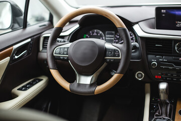 Interior view of car, luxury car steering wheel and dashboard with display or monitor screen.