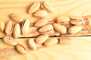 Organic salted pistachios, close-up, on a wooden table.