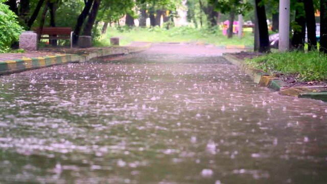 drops of summer or autumn rain of water fall on asphalt in the city turning into a large puddle, flooding the street. Drops of rain fall. slow motion, general paln