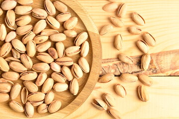 Organic salted pistachios, close-up, on a wooden table.