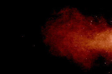 Red powder explosion isolated on black background.