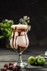 Sweet chocolate milkshake cocktail with chocolate syrup on black background