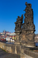 Fototapeta premium Autumn colorful Prague Lesser Town with gothic Castle from Charles Bridge with its baroque Sculpture, Czech Republic