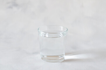 Glass of pure water on the grey background. Copy space