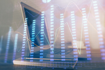 Financial chart drawing and table with computer on background. Multi exposure. Concept of...