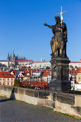 Fototapeta premium Autumn colorful Prague Lesser Town with gothic Castle from Charles Bridge with its baroque Sculpture, Czech Republic