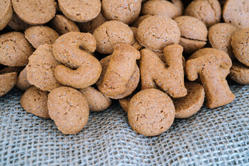Dutch holiday Sinterklaas background with kruidnoten, traditional Sinterklaas sweets.. Pepernoten on sacking for sweets and gift boxes. Concept for children party Saint Nicolas day five december.