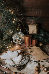 Extinct Christmas candles. Homemade cookies in powdered sugar. Vintage tableware for christmas. Letter in an envelope. Burning candles. Christmas atmosphere. Festive Christmas table. Holiday mood.