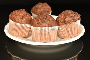 delicious chocolate muffins, close-up, on a black background.