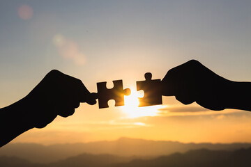 Silhouette Woman hands connecting couple jigsaw puzzle piece against sunrise, Business solutions, target, success, goals and strategy concepts