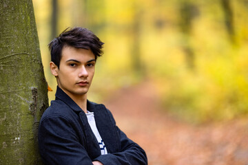 Portrait with a handsome young man in autumn forest, fashion concept.