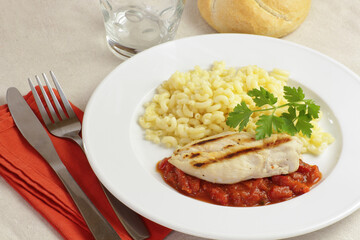 escalope de poulet grillée à la sauce tomate et pâtes dans une assiette