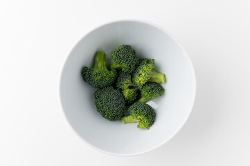 Fresh Healthy vegetables and food. Raw broccoli cut into small pieces and put in white bowl background.