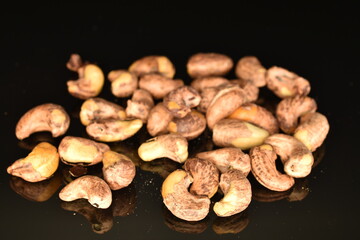 Fragrant roasted cashews, close-up, on a black background.