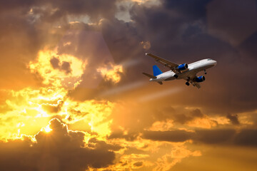 Fototapeta na wymiar airplane fly over dramatic sunset