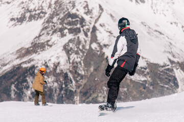 Fototapeta na wymiar People ski and snowboard at a beautiful resort in the mountains of Georgia
