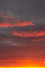 Wonderful November sunset with bright red-pink clouds on a dark gray-blue sky
