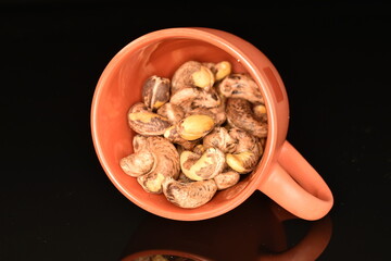 Fragrant roasted cashews, close-up, on a black background.
