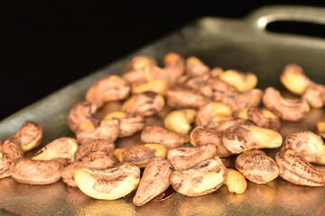 Fragrant roasted cashews, close-up, on a black background.
