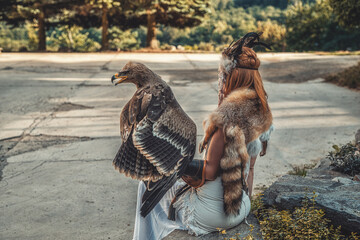 beautiful shamanic woman with eagle in the nature.