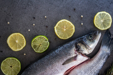 Fresh ingredients top view photo. Trout fish with potatoes, lemon slices and rosemary on gray table. 