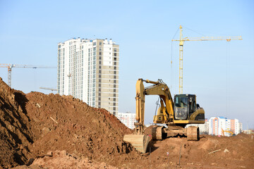 Excavator during earthmoving at construction site. Backhoe dig ground for the construction of...