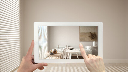 Augmented reality concept. Hand holding tablet with AR application used to simulate furniture and design products in empty interior with ceramic tiles. Living room, sofa, tables