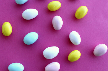 Colored almond candies on pink background