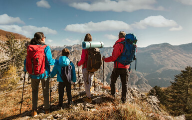 Family with two kids hiking in mountains