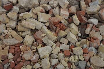stone texture from pieces of old brown gray bricks in a heap on the street