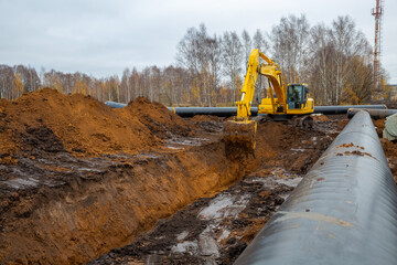 laying the pipeline with an excavator. Autumn, shooting from a drone. Earthworks, infrastructure...