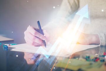 Blue arrow over woman's hands taking notes background. Concept of success. Double exposure