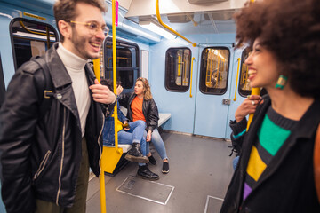 Multiethnic friends travelling underground chatting together having fun enjoying trip