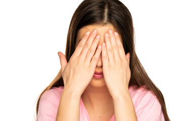 Young woman covers the eyes with her hands