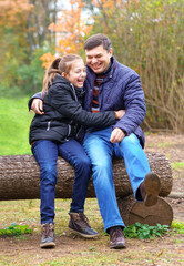 father and daughter, family relaxing outdoor in autumn city park, happy people together, parent and children, they playing and smiling, beautiful nature