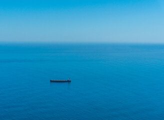 Cargo ship waiting in the middle of blue sea 